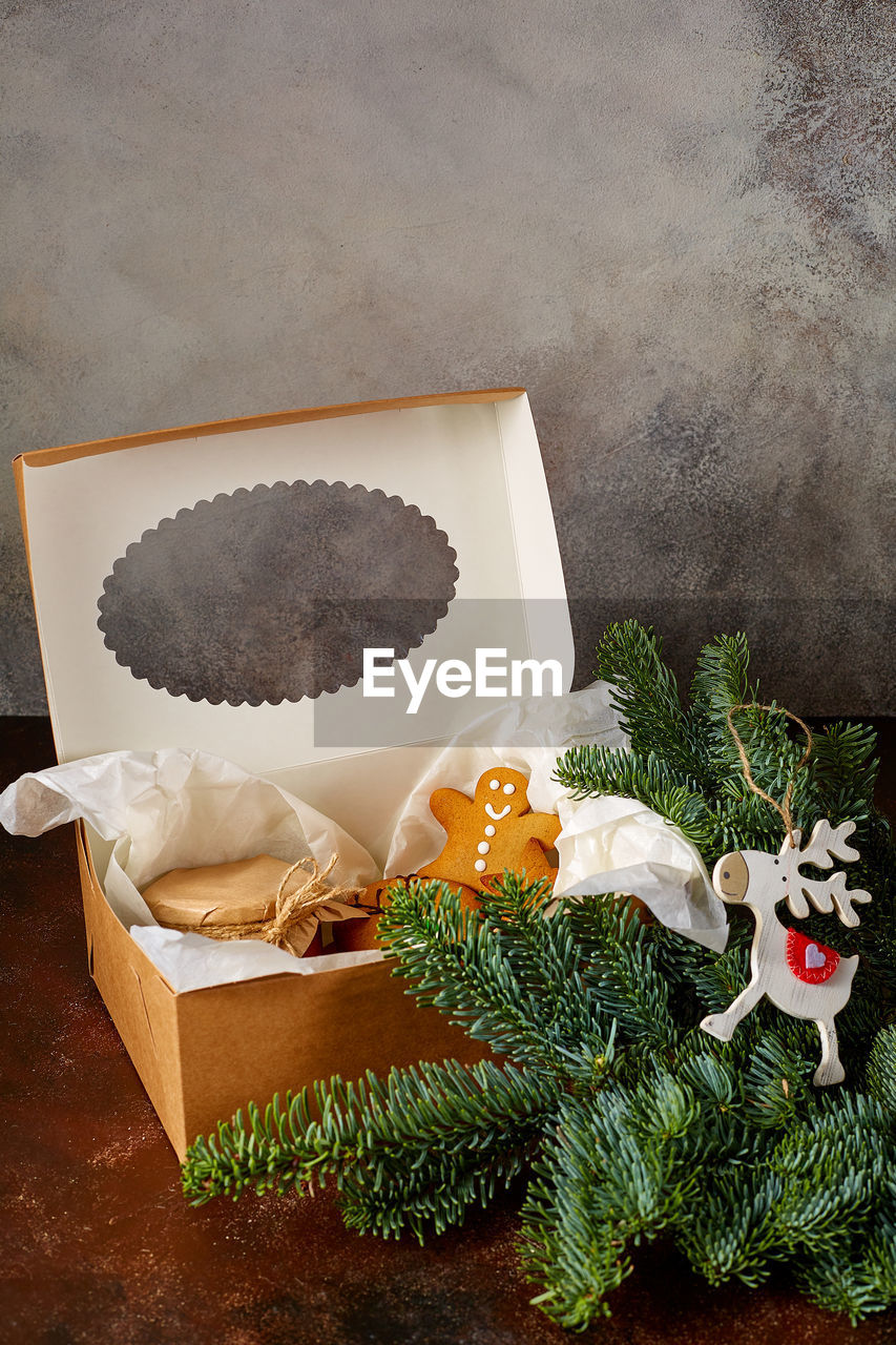 High angle view of christmas decorations with gingerbread cookies in box on table