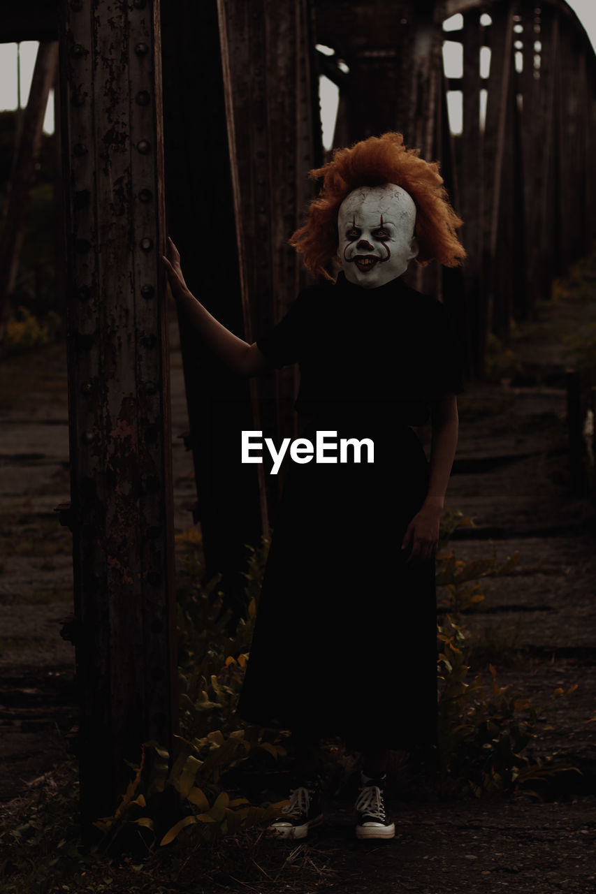 Young woman with mask standing in bridge