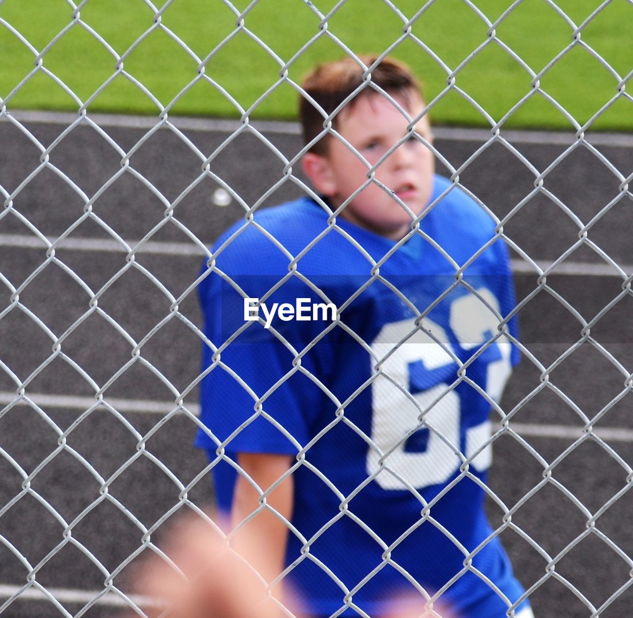 High angle view of american football player seen through chainklink fence