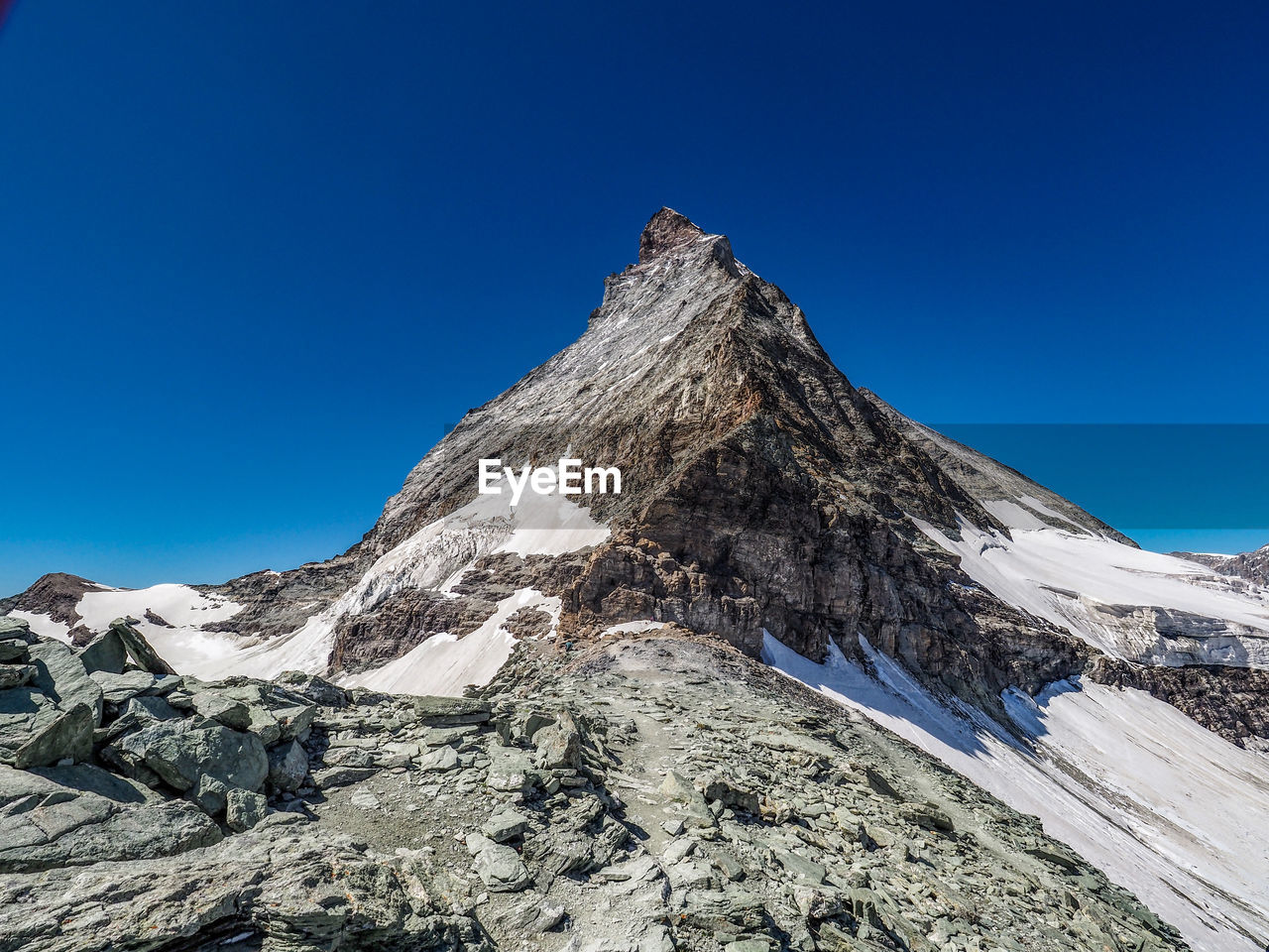 Scenic view of snowcapped mountain against clear blue sky