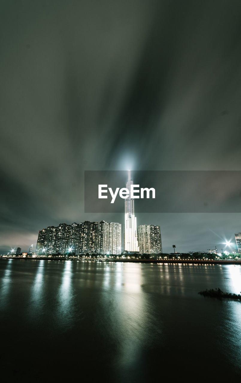 Illuminated city buildings against sky at night