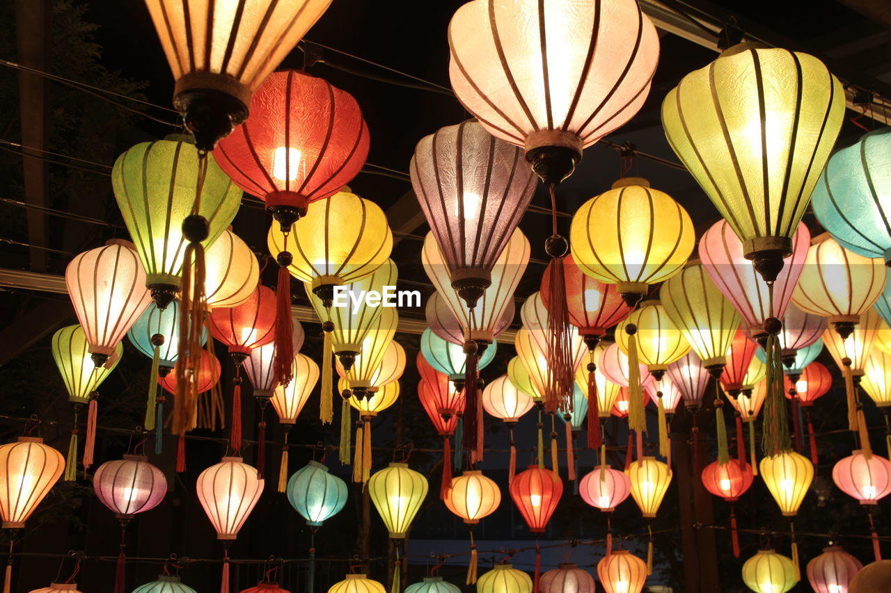 Low angle view of illuminated multi colored lanterns hanging from ceiling