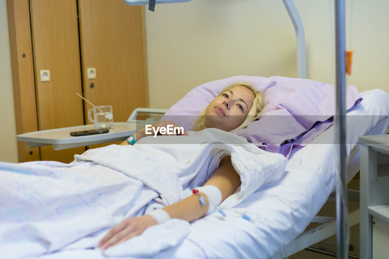 Woman lying on bed in hospital