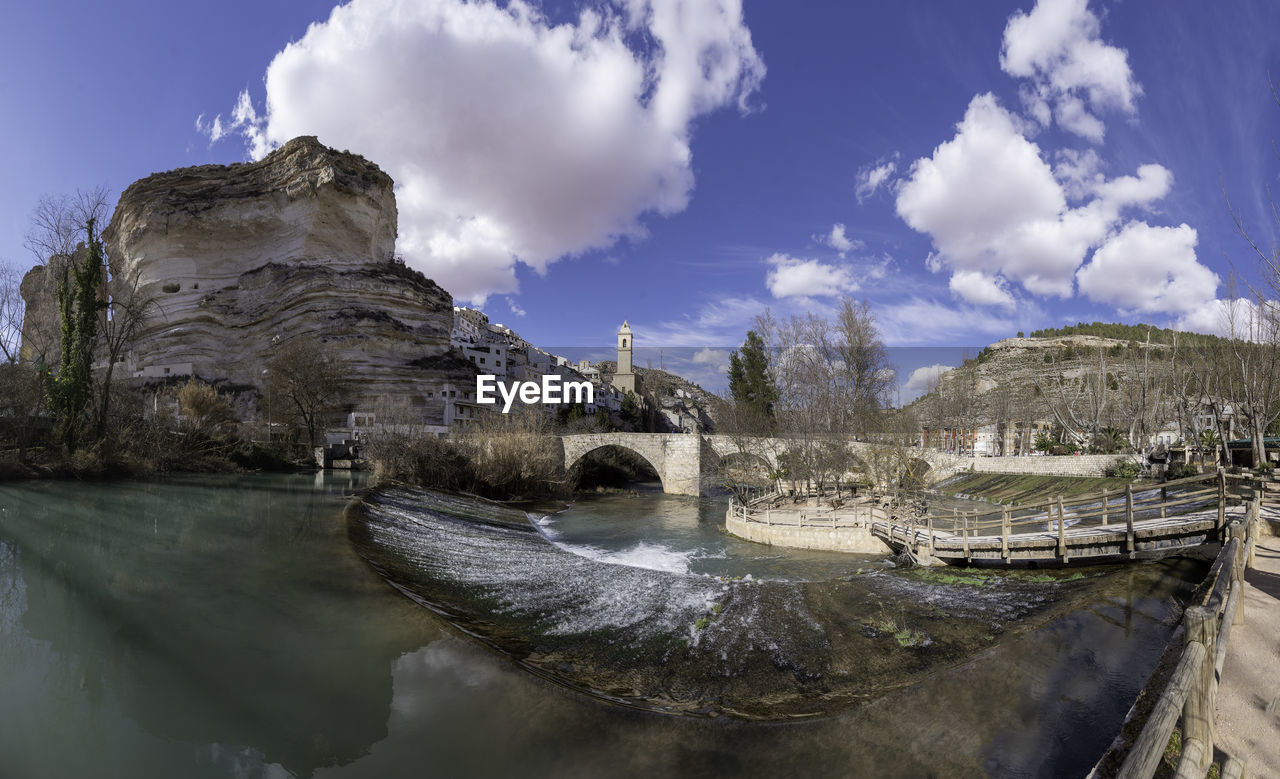 sky, water, reflection, cloud, nature, rock, environment, architecture, scenics - nature, travel destinations, travel, landscape, river, beauty in nature, no people, mountain, outdoors, built structure, tree, land, blue, history, tourism, tranquility, day, the past, plant, panoramic, non-urban scene