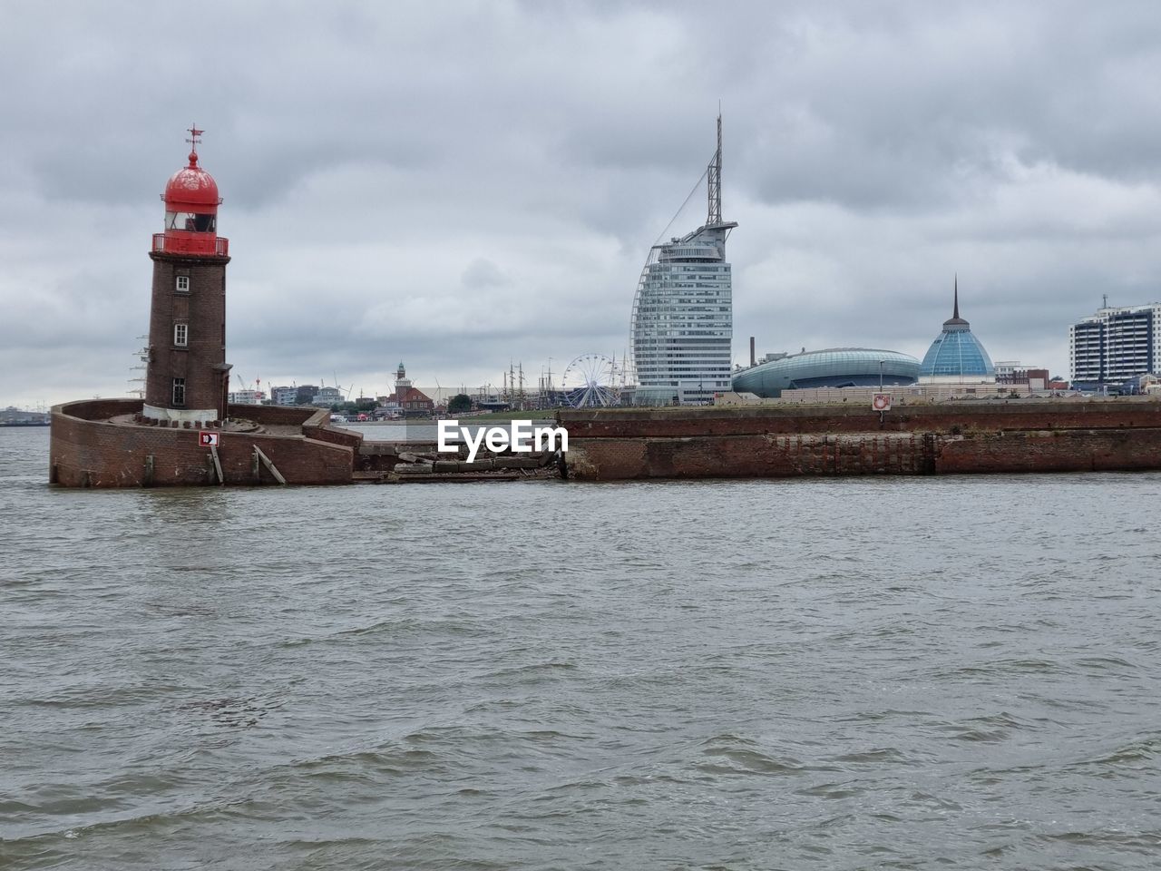 architecture, built structure, building exterior, water, building, lighthouse, tower, city, sky, travel destinations, sea, cloud, harbor, travel, landscape, nature, coast, urban skyline, environment, guidance, nautical vessel, transportation, tourism, the past, no people, history, cityscape, vehicle, beach, waterway, protection, outdoors, industry, overcast, day, channel, land, business finance and industry, security, coastline, scenics - nature, trip, vacation, waterfront, beauty in nature, holiday, social issues, water's edge