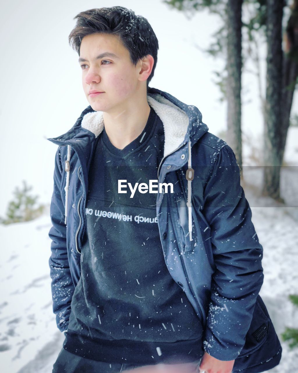 YOUNG MAN STANDING ON SNOW