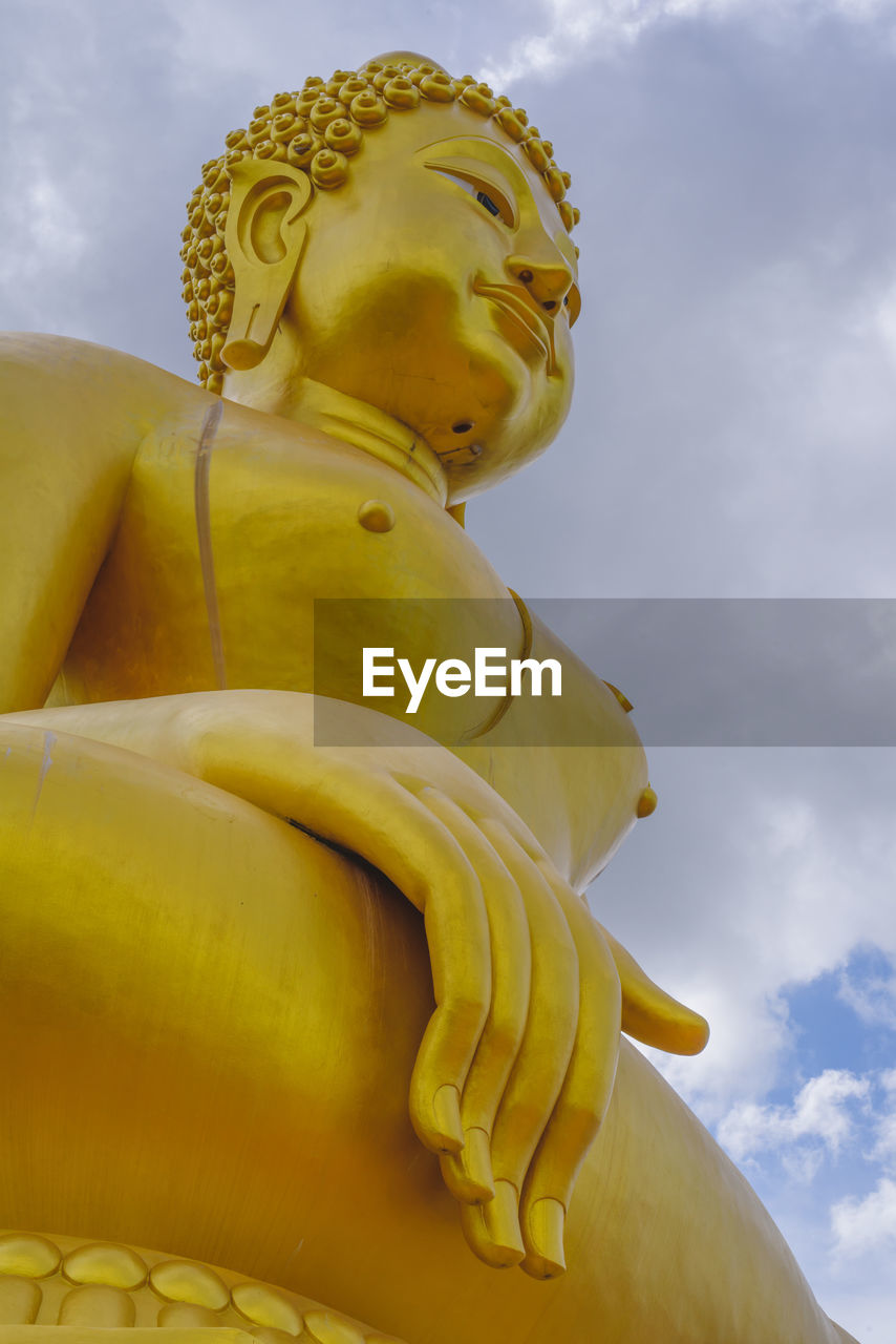 LOW ANGLE VIEW OF STATUE OF YELLOW SCULPTURE AGAINST SKY