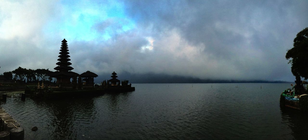 Silhouette pura ulun danu bratan against cloudy sky at dusk