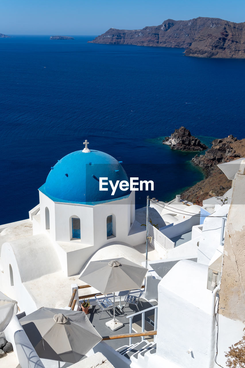 Beautiful view of oia town in santorini island with whitewashed churches with blue roof, greece
