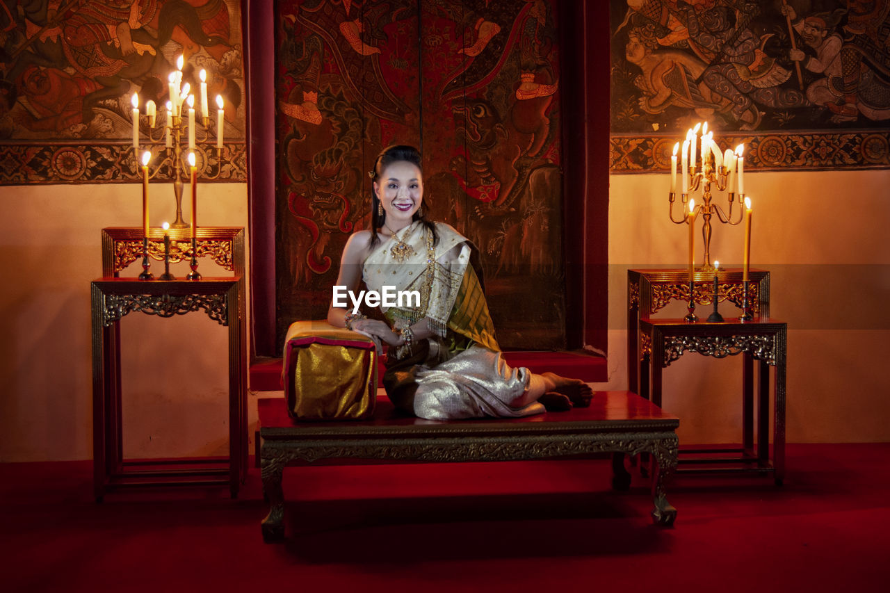 Woman sitting on table in illuminated room