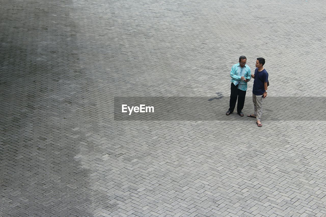 High angle view of people talking while standing on city street