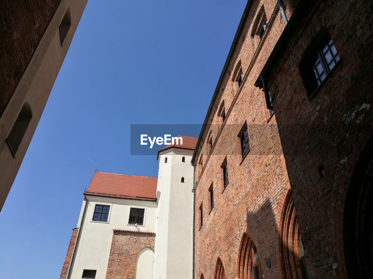 LOW ANGLE VIEW OF BUILDINGS AGAINST BLUE SKY