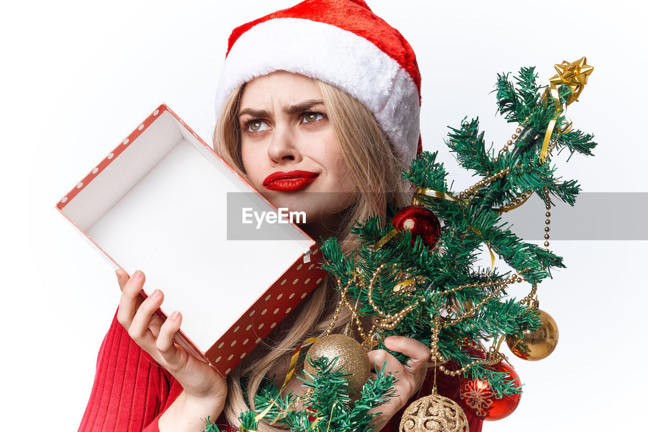 MIDSECTION OF WOMAN HOLDING UMBRELLA WITH CHRISTMAS DECORATIONS