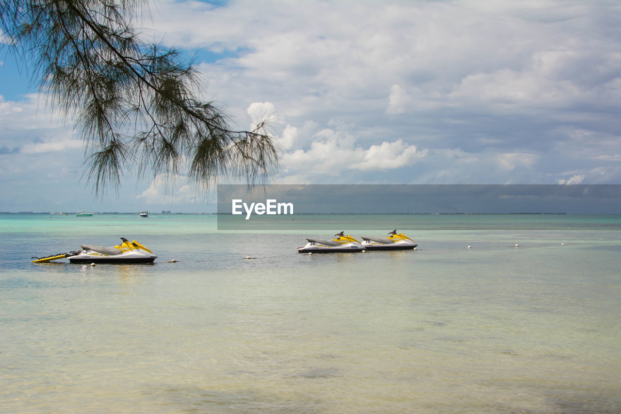 Jet skis in the caribbean water against sky