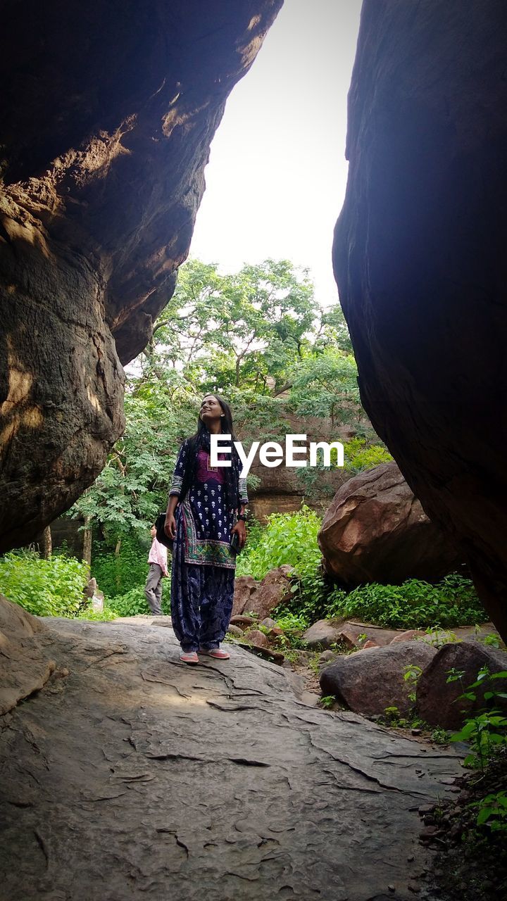 REAR VIEW OF MAN ON ROCKS