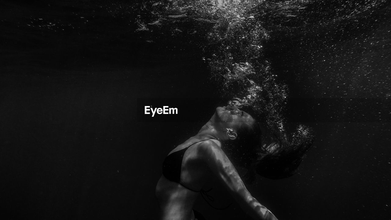 Side view of young woman swimming in sea