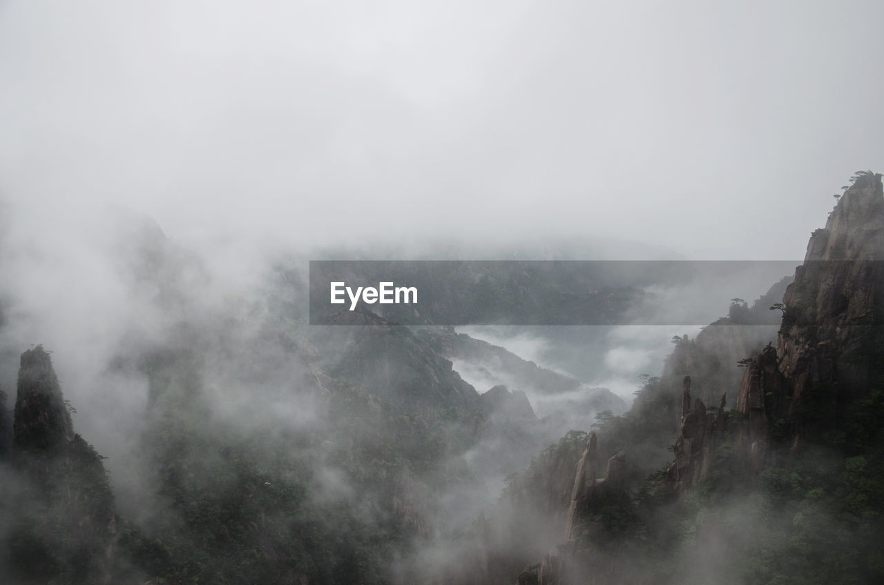 SCENIC VIEW OF MOUNTAINS AGAINST SKY DURING FOGGY WEATHER