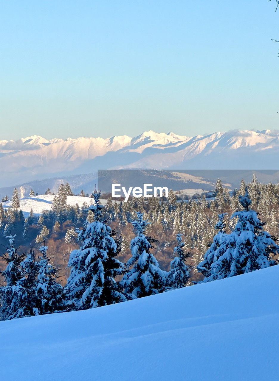 aerial view of snow covered mountains against clear sky