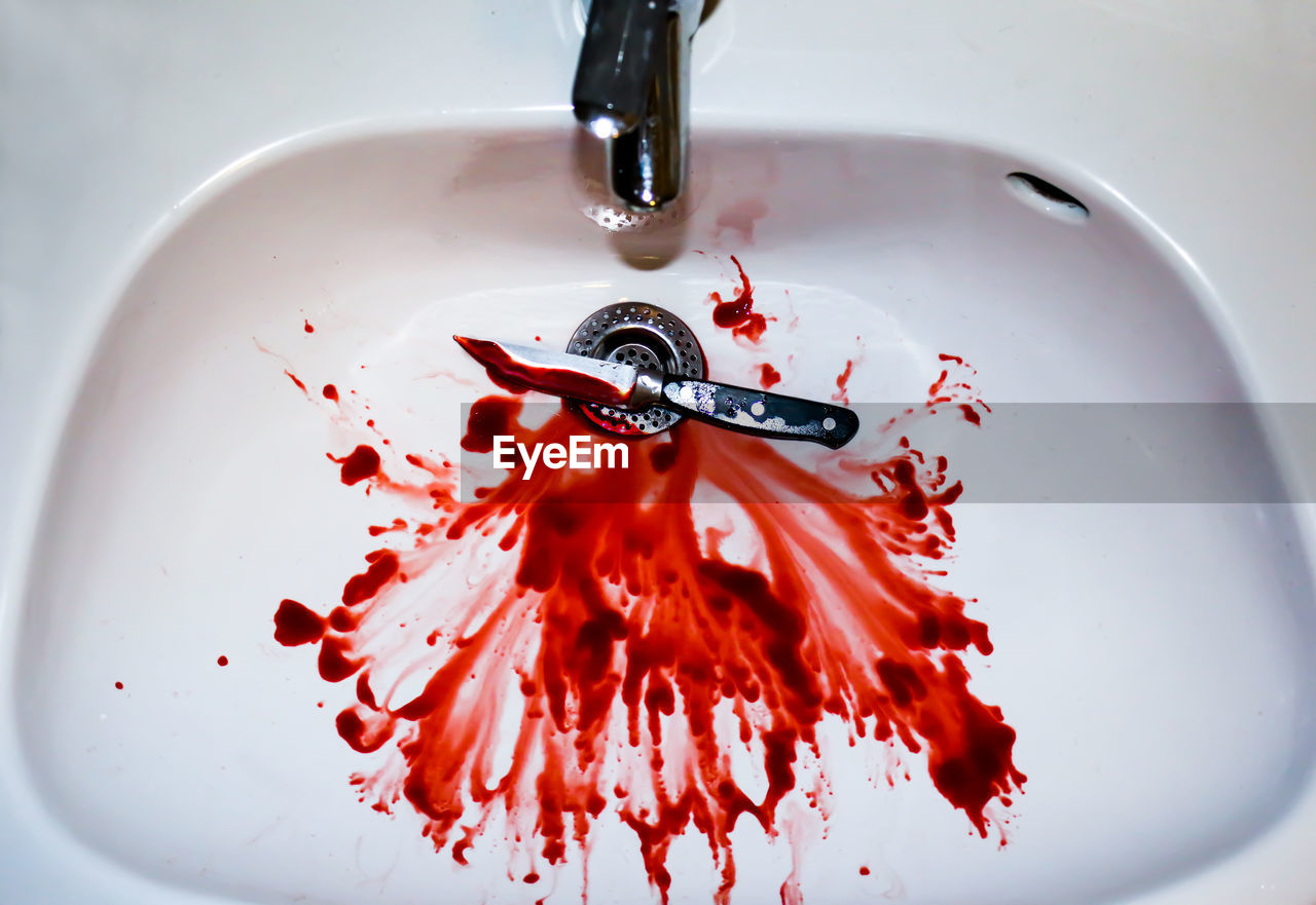 High angle view of blood with knife in sink