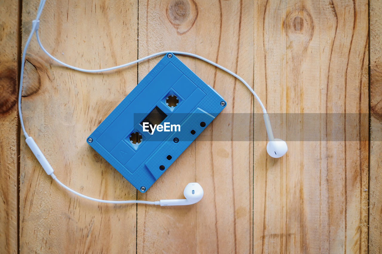 High angle view of audio cassette and headphones on table