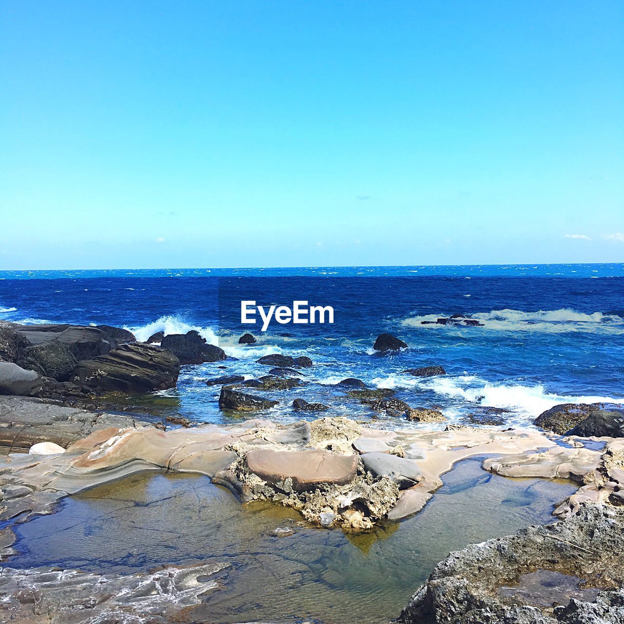 View of calm beach against blue sky