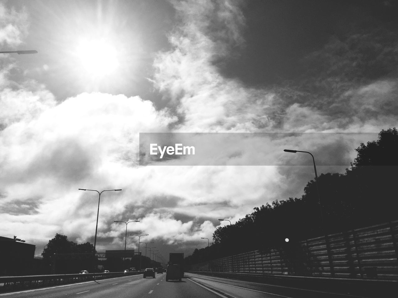 LOW ANGLE VIEW OF ROAD AGAINST CLOUDY SKY