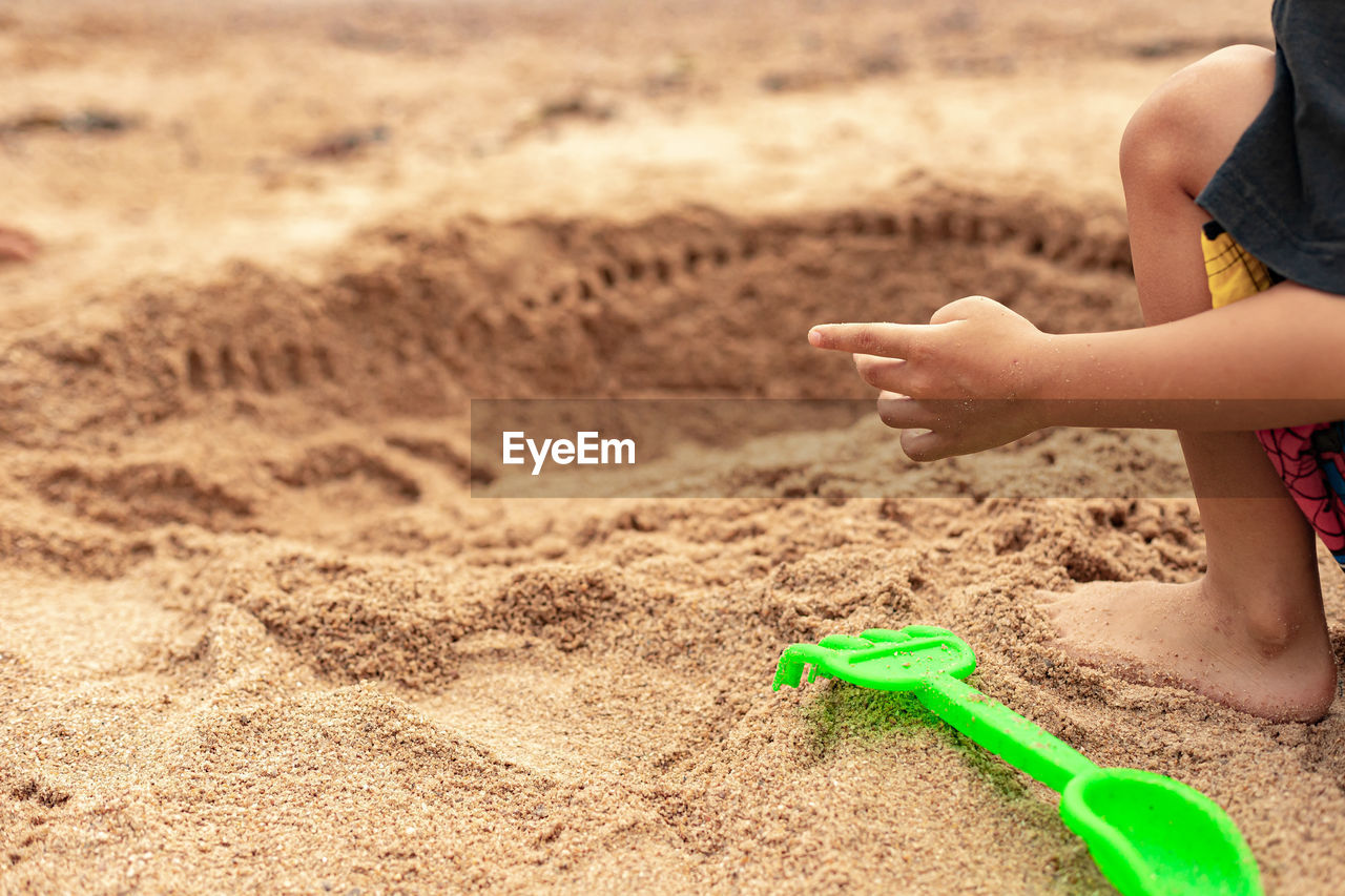 Boy playing with toy on sand