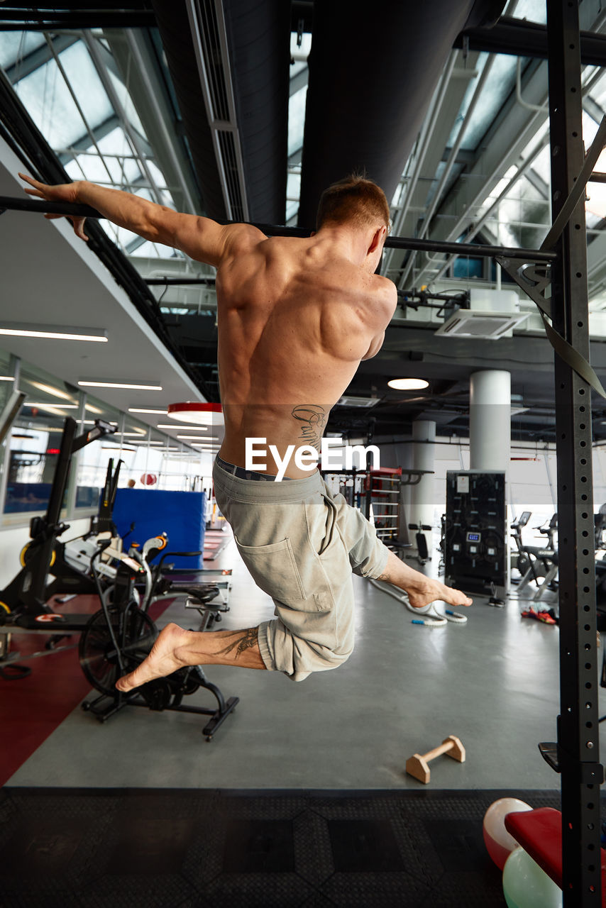 Shirtless man exercising in gym