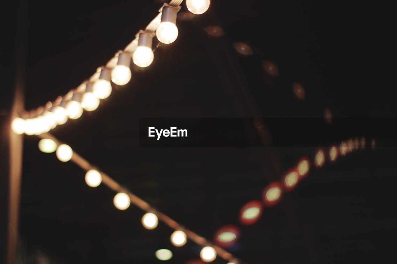 CLOSE-UP OF ILLUMINATED LIGHTS AT NIGHT