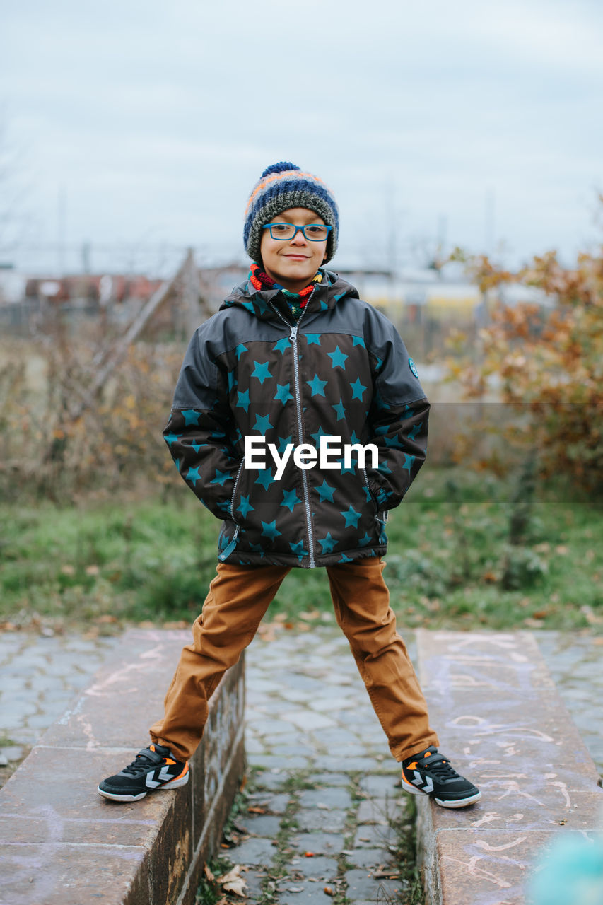 Portrait of cute boy wearing knit hat standing outdoors during winter