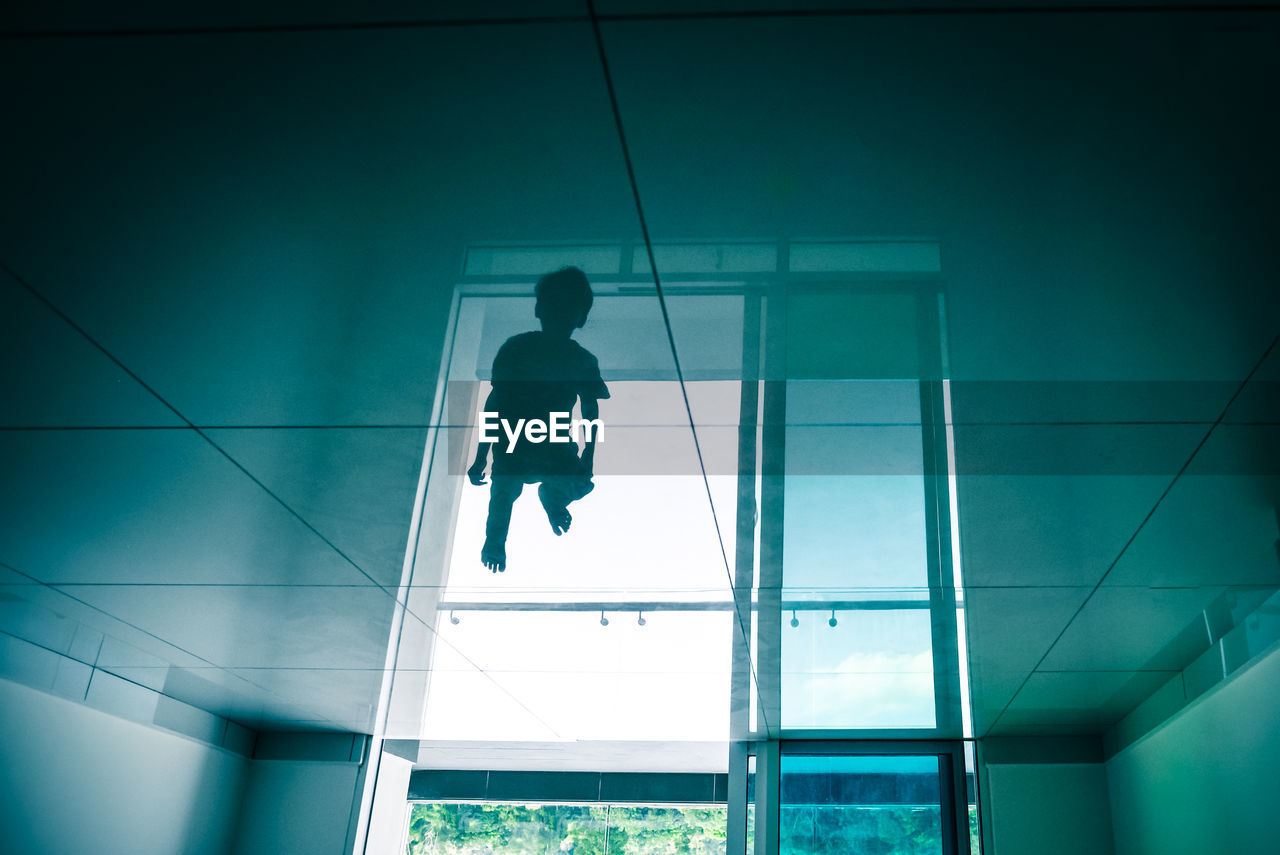 Reflection of boy on floor