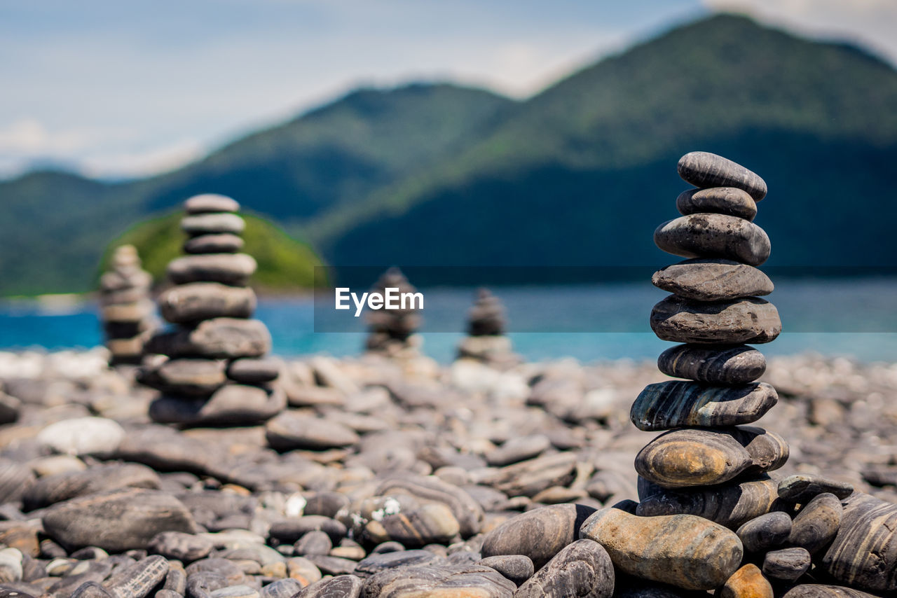 Stone stack at lakeshore against mountains