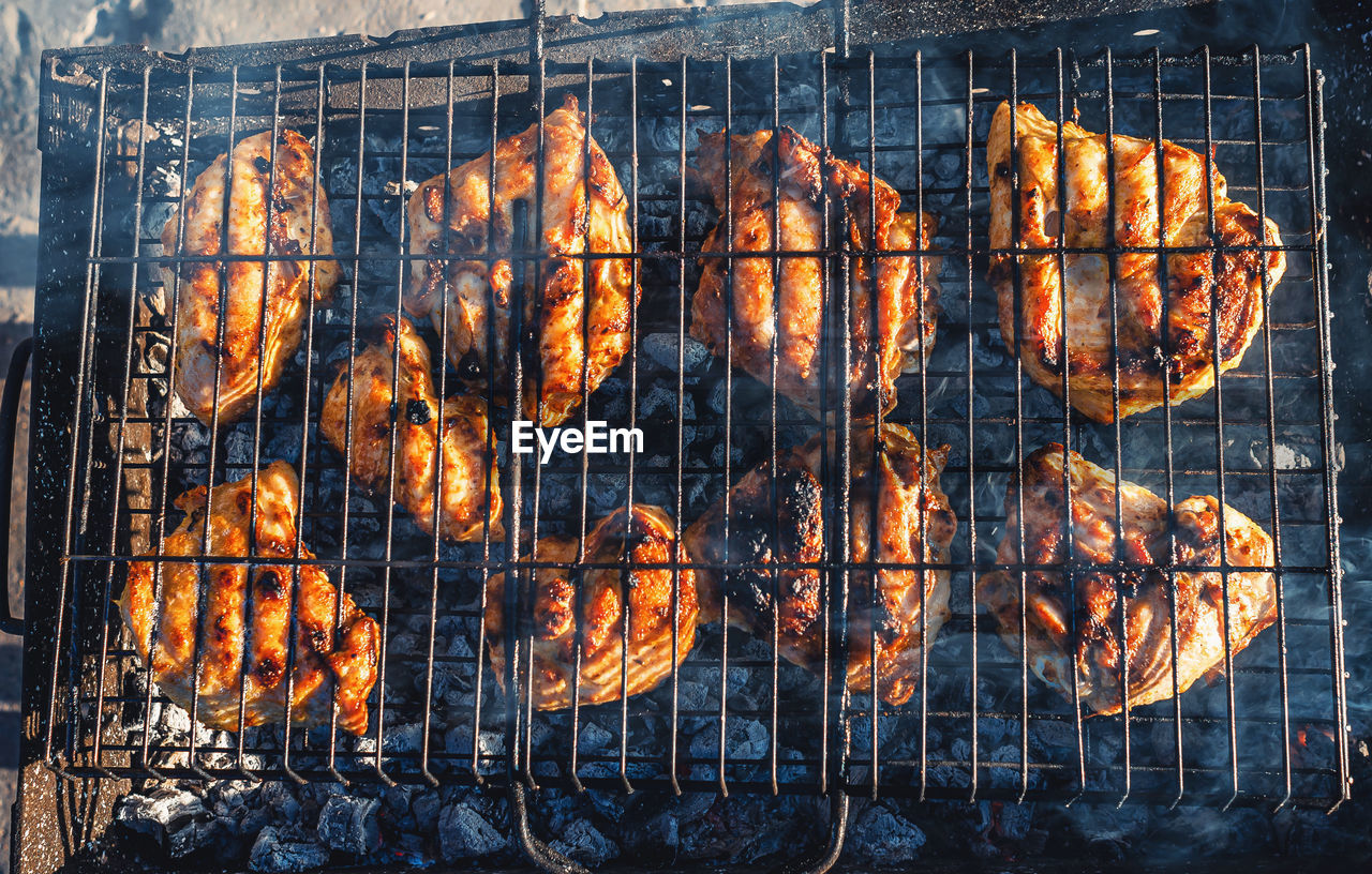 Mouthwatering chicken drumsticks roasting on an open flame, culinary work of art