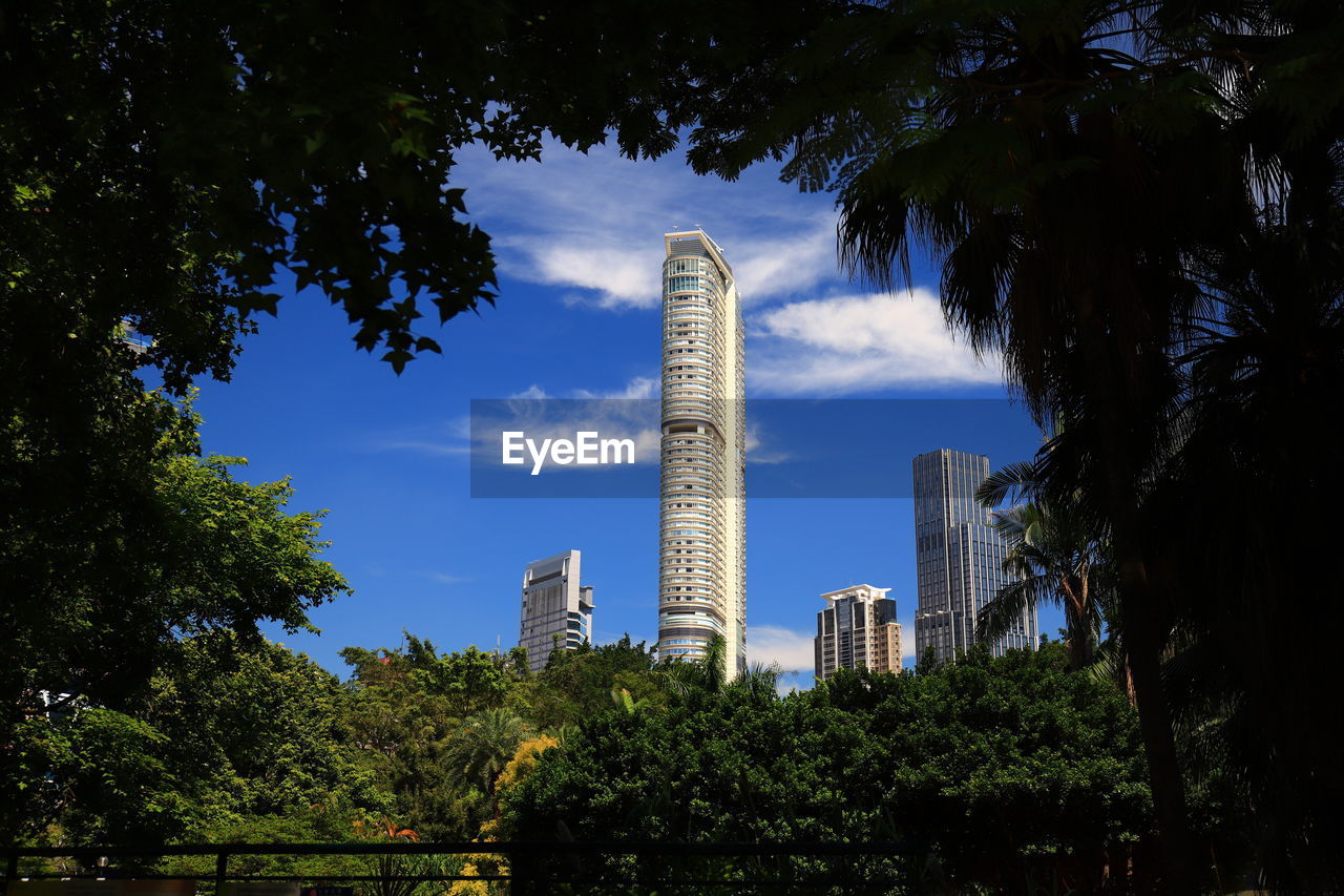 Low angle view of trees and buildings against sky