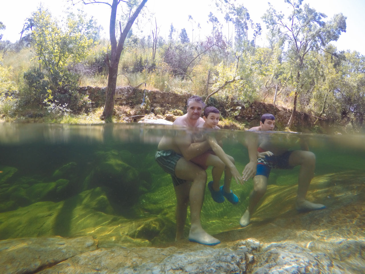 Portrait of shirtless family enjoying in lake