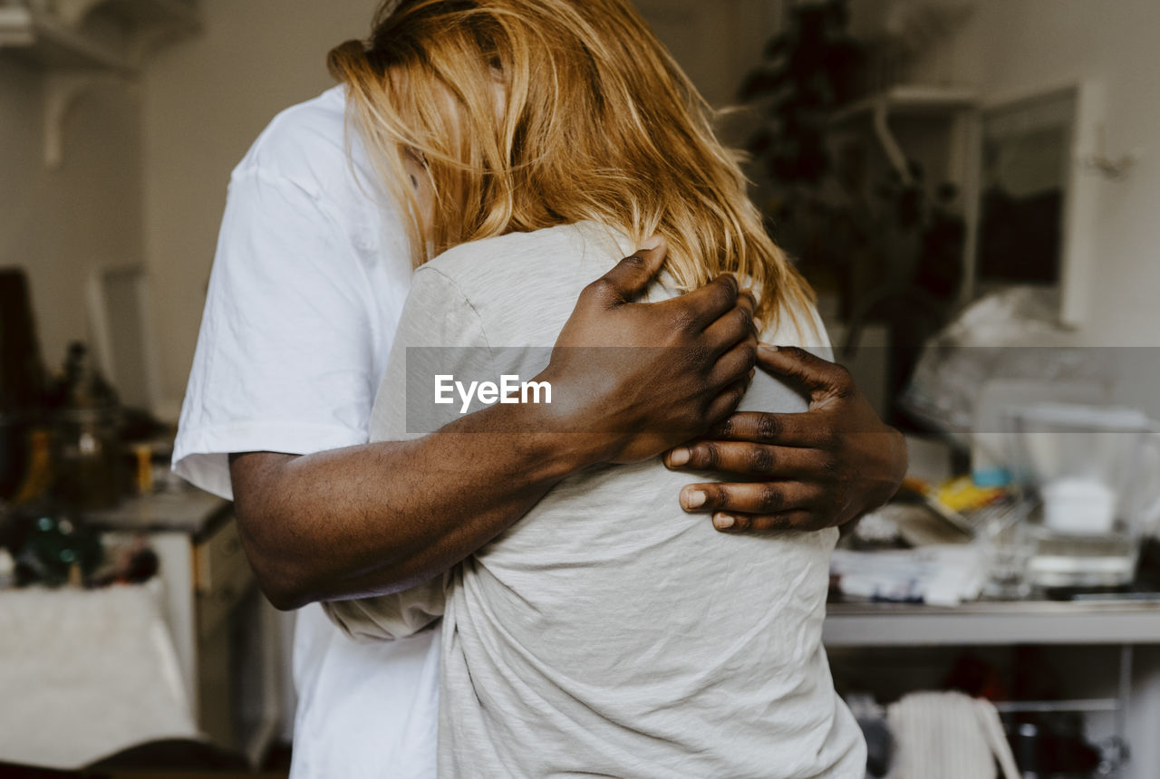 Son embracing mother in living room