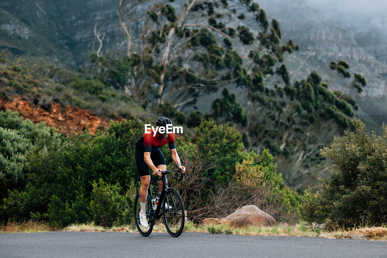 rear view of woman riding bicycle on mountain