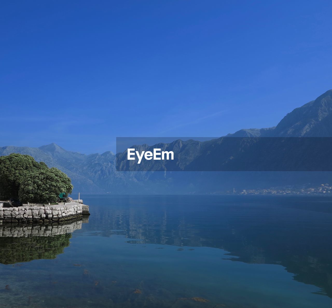 Scenic view of lake by mountains against sky