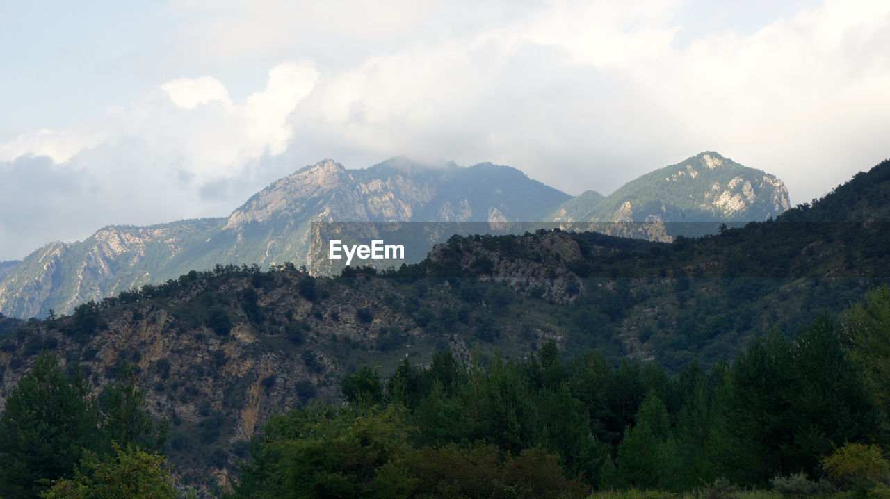 Scenic view of mountains against cloudy sky