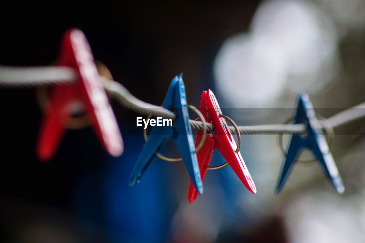 Close-up of clothespins hanging on rope