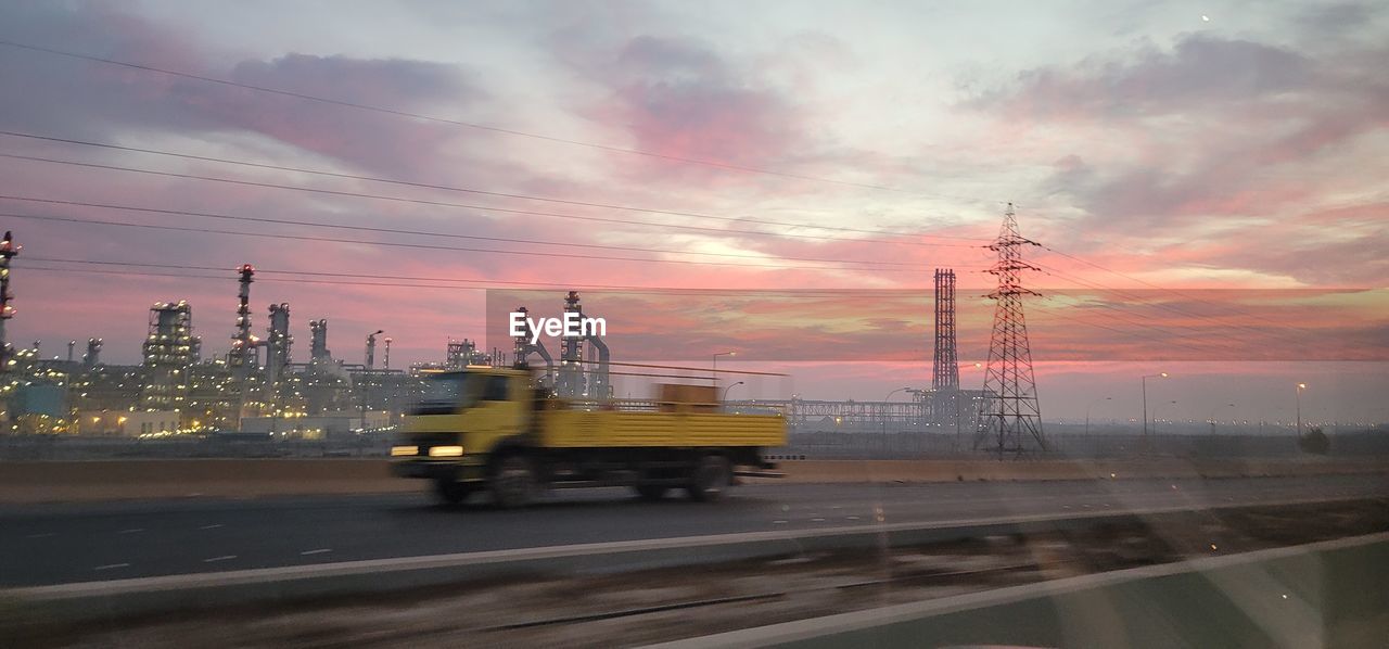 Truck on road against sky during sunset