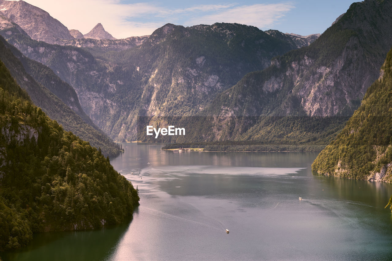 Scenic view of lake by mountains against sky