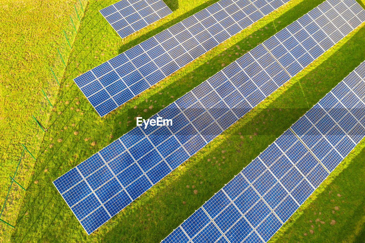 High angle view of solar panels on grassy field