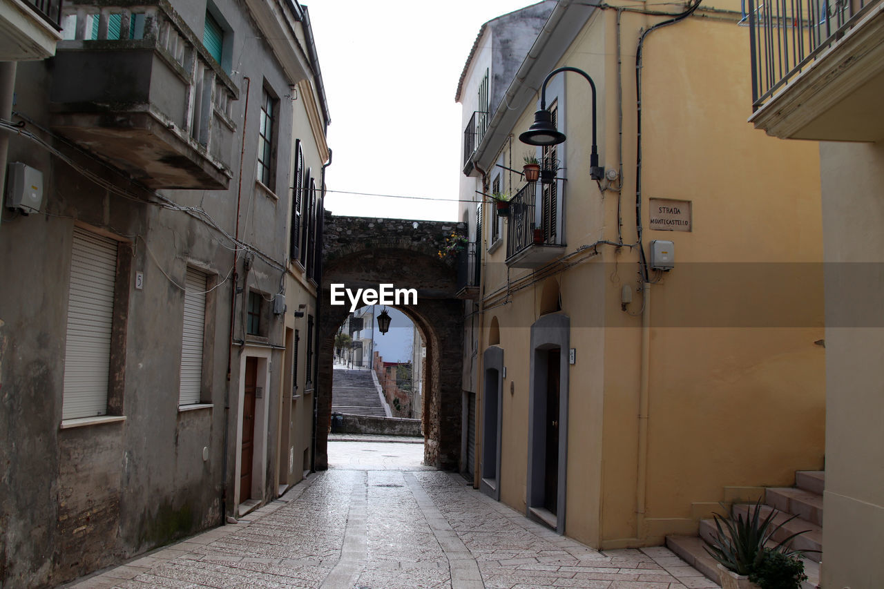 architecture, alley, road, building exterior, built structure, street, building, town, city, house, neighbourhood, residential district, the way forward, infrastructure, nature, facade, day, narrow, no people, outdoors, entrance, urban area, window, door, sky, footpath