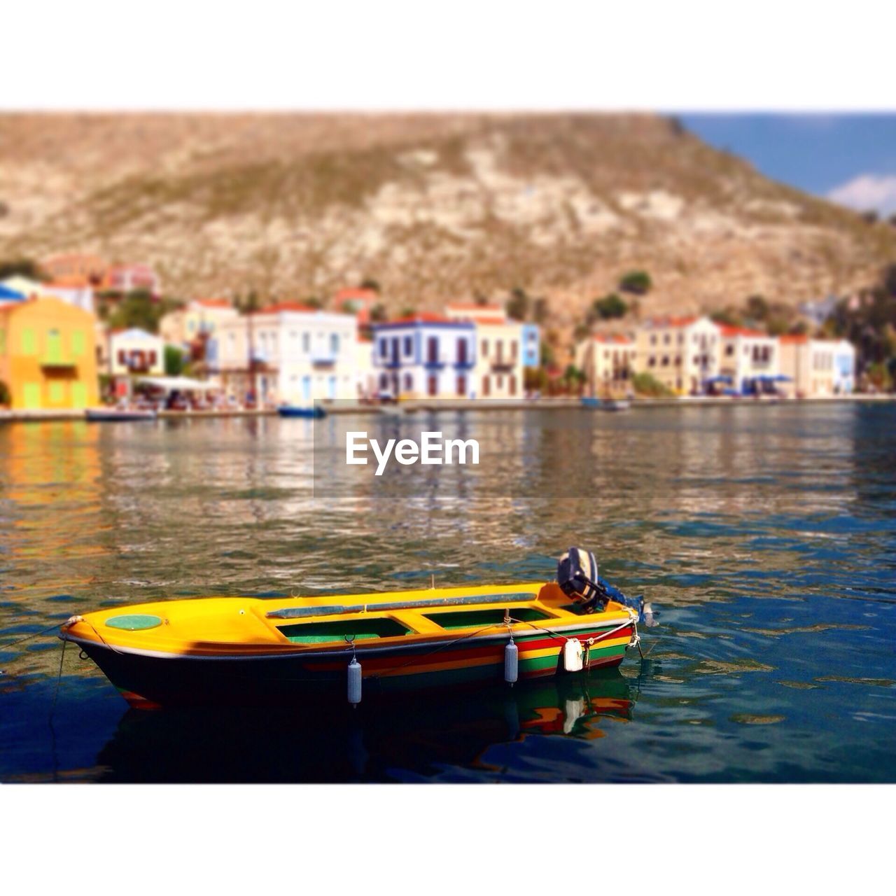 Nautical vessel moored on lake against houses