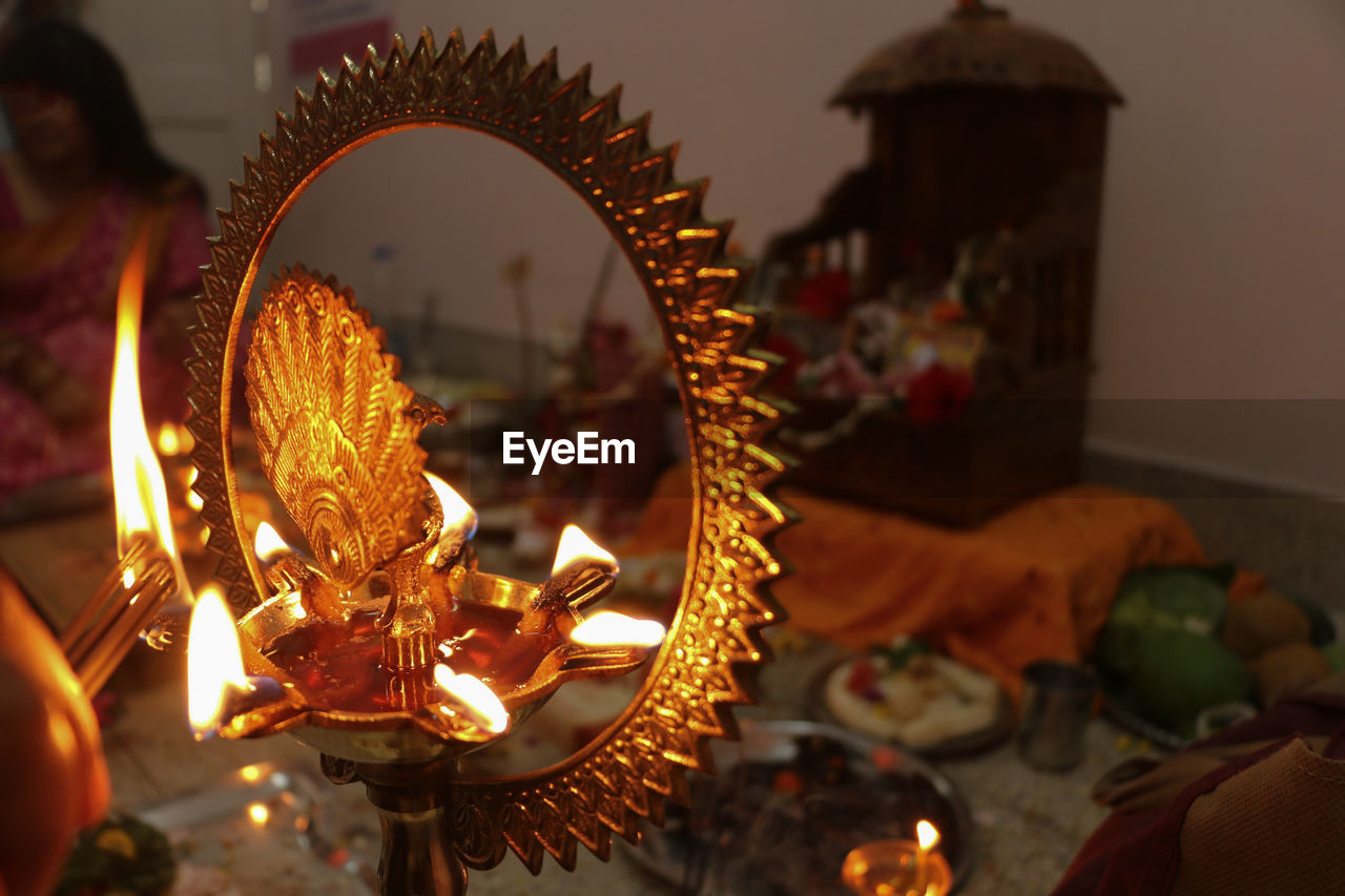 Puja set up in hinduism. selective focus on burning traditional brass lamp called diya .