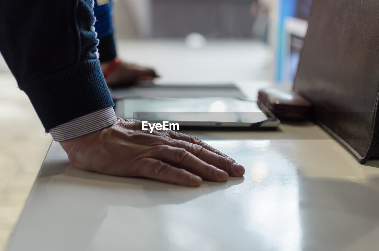Cropped hands of businessman using digital tablet at desk