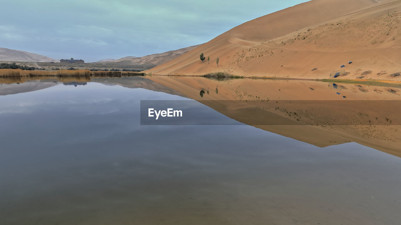 1032 lake badain east reflects a megadune of the badain jaran area-gobi desert. inner mongolia-china