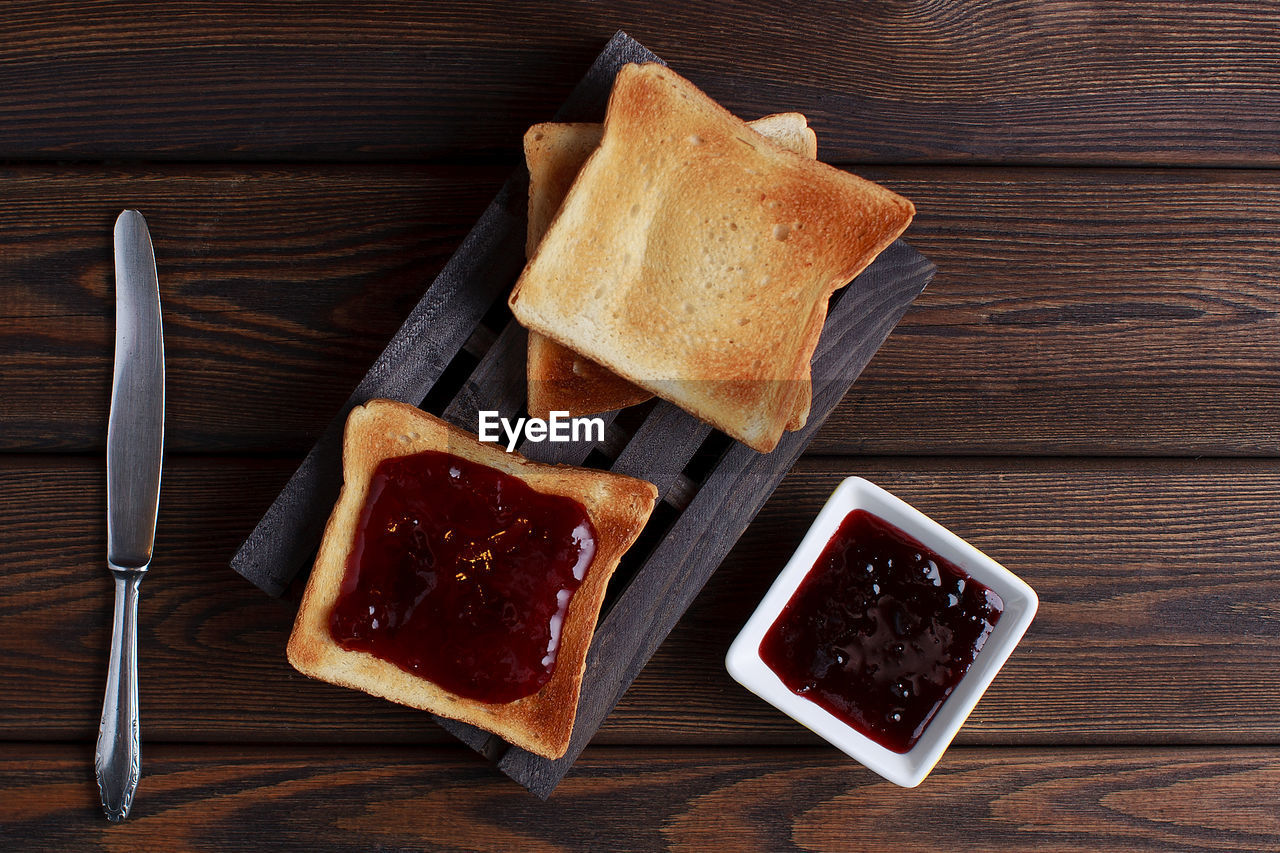 Toasts with jam on dark wooden table