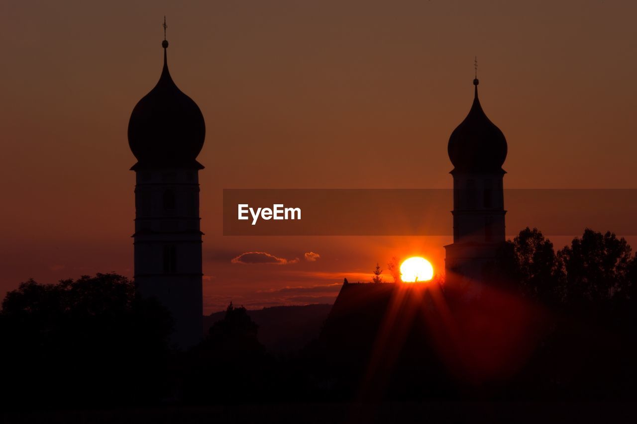 SILHOUETTE BUILDING AGAINST ORANGE SKY